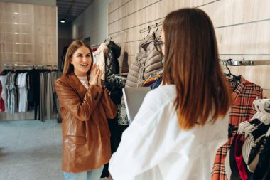 Profesyonel Alışveriş Asistanı Dijital Tablet Kullanarak Kadın Müşterinin Kıyafet Almasına ve Kişisel Stili Geliştirmesine Yardım Ediyor. Boş Alan