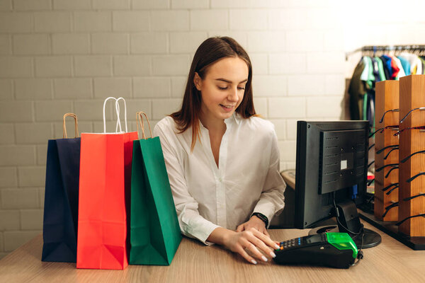 Seller with payment terminal in modern shop