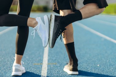 Şafakta koşucuların bacakları. Stadyumda koşu. Eğitim sporcuları.