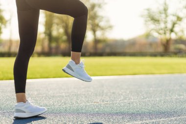 Şafakta koşucuların bacakları. Stadyumda koşu. Eğitim sporcuları.