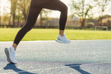 Şafakta koşucuların bacakları. Stadyumda koşu. Eğitim sporcuları.