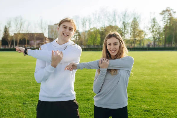 Young Sports Couple Trains Stadium Summer Doing Various Stretching Exercises — Fotografia de Stock