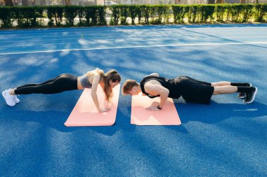 Genç çift stadyumda şınav yapıyor