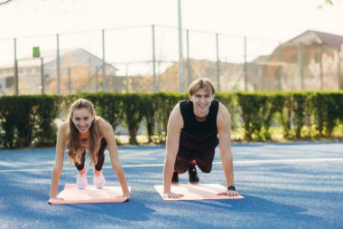 Genç çift stadyumda şınav yapıyor