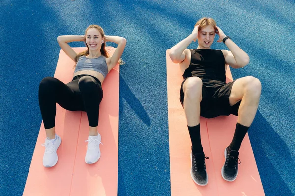Young Couple Doing Sports Exercises Yoga Mat Stadium — Stockfoto