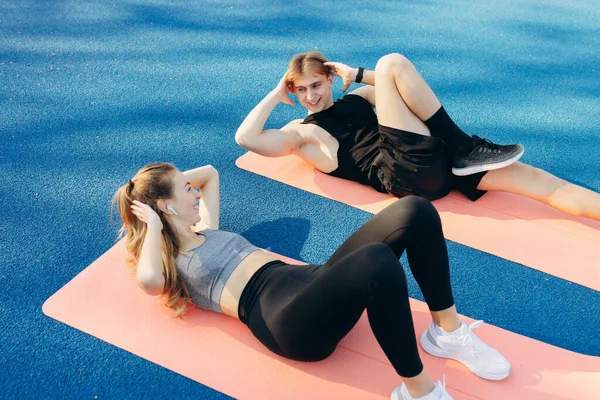 Young Couple Doing Sports Exercises Yoga Mat Stadium — Stockfoto