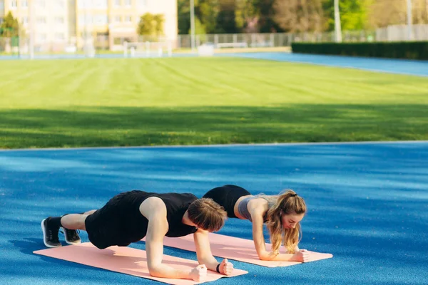 Young Fitness Woman Man Doing Plank Exercises Together Stadium — Stockfoto