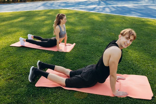 Photo Beautiful Happy Couple Sportswear Performing Stretching Exercises Yoga Mat — Stockfoto
