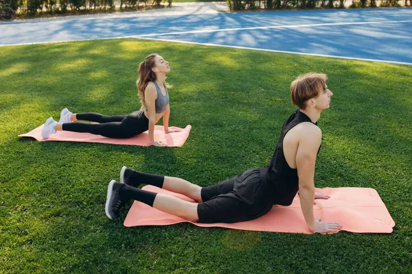 Photo Beautiful Happy Couple Sportswear Performing Stretching Exercises Yoga Mat — Stockfoto