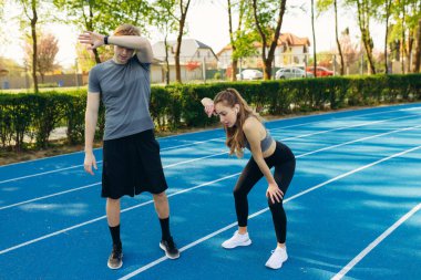 Yorgun sporcular koşudan sonra dinleniyor