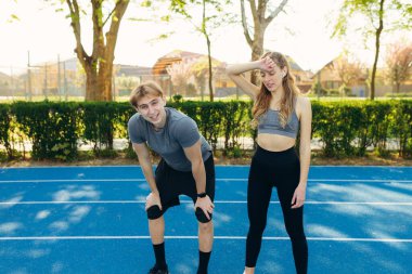 Formda bir çift hızlı koşudan sonra dinleniyor - Koşucular gün batımında spor, sağlık, spor, spor, spor, spor ve sağlıklı yaşam tarzı konseptinde antrenman yapıyorlar.