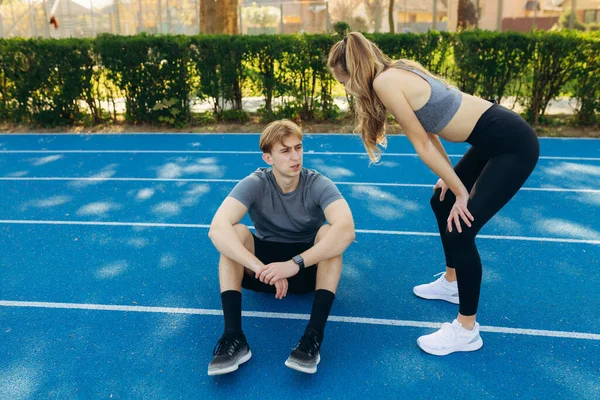 Yorgun sporcular koşudan sonra dinleniyor