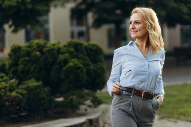 Portrait senior business professional walking outside Mature business woman walking outdoors on street. Success