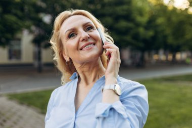 İnternetteki akıllı telefon danışmanı müşteriyle mutlu yaşlı iş kadını sohbetini kapat, gülümse son sınıf güzeli. Teknoloji konsepti