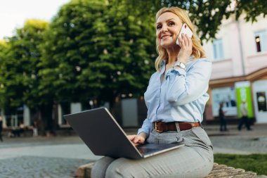 Portrait of a mature businesswoman working with laptop in the city. Lifestyle concept