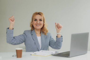 Mutlu, olgun, yaşlı bir kadın kazanan, güzel haberler okuyan, dizüstü bilgisayara bakan, mutlu, yaşlı bir kadın online bahis zaferi ya da harika bir sonuç alma kavramını izliyor.