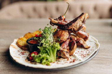 Biberiyeli pirzola, rustik patates, soğan, tabakta sos. Metin için yer, kopyalama alanı