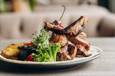 Biberiyeli pirzola, rustik patates, soğan, tabakta sos. Metin için yer, kopyalama alanı