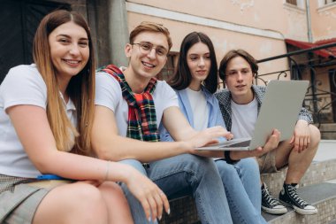 Mutlu genç öğrenciler kampüste sohbet ediyor