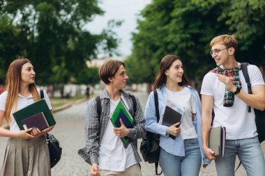 Group of teenage students standing outdoors. Friends are smiling and happy