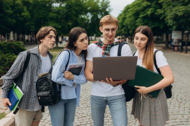 Young people looking at laptop together