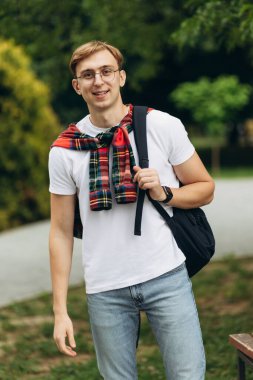 portrait of an attractive guy in student glasses with a backpack. Learning concept