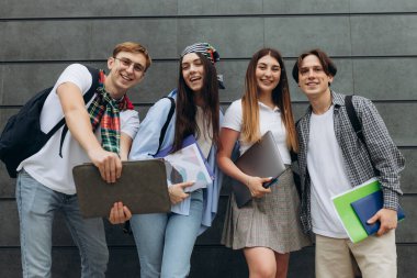 Smiling group of students holding notebook books and study notebooks. Happy friends. Learning concept. Copy space