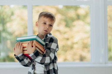 Portrait of a happy schoolboy with a book in his hand. First time to school. Back to school.