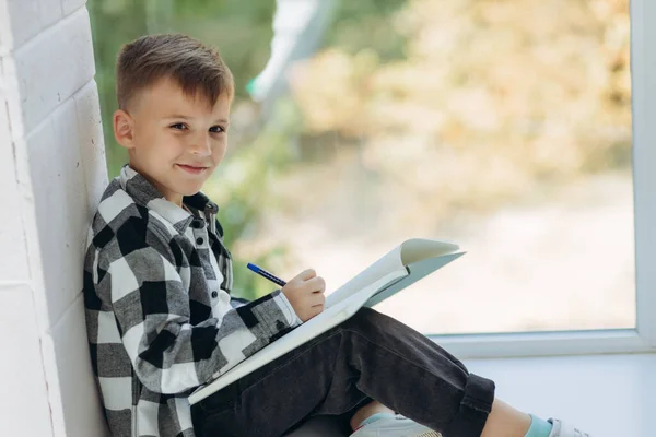 Πορτραίτο Ενός Αγοριού Που Διαβάζει Αγόρι Κάθεται Στο Περβάζι Του — Φωτογραφία Αρχείου