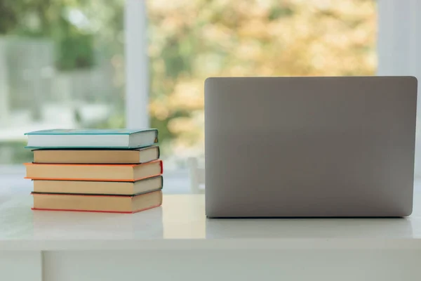 Close up of books and laptop on table at home. Student's place of study. Place for your text