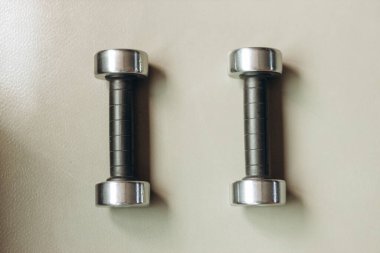 Fitness concept. Equipment for fitness exercise dumbbells. Gray background.