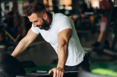 Exhausted mid adult man on gym treadmill