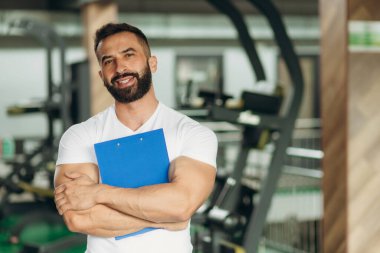 Kişisel antrenör Pano eğitim planı ile spor salonunda tutan portresi