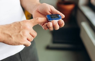 Close up of Finger and hand in an Oximeter Device. Pulse oximeter