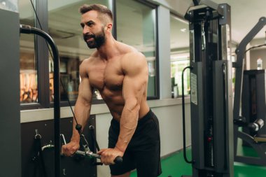 man doing exercises on muscles of triceps in simulator. Muscles on arms, ligaments. Concept workout, bodybuilder in gym