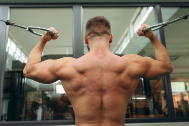 Man doing exercises on the simulator. Back view