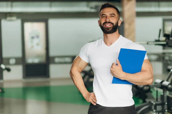 Kişisel antrenör Pano eğitim planı ile spor salonunda tutan portresi