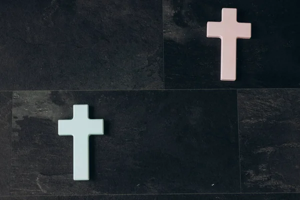 Two Christian cross on a textured black background. Religion concept.