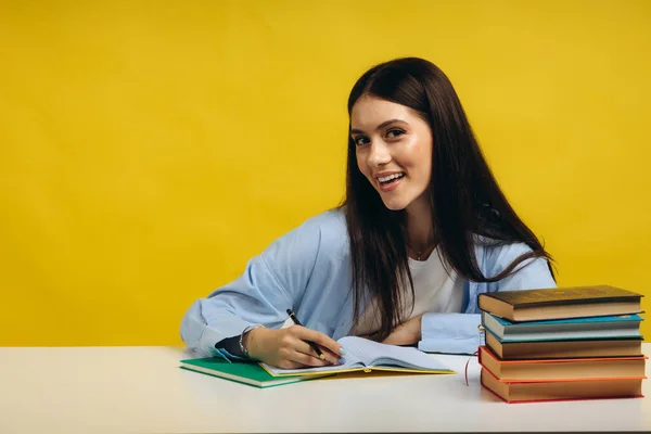 Beautiful Smiling Woman Sitting Table Writing Her Notebook Yellow Background — Foto de Stock