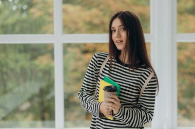 Portrait of a smiling student girl with notebooks and a backpack. The concept of school and college education