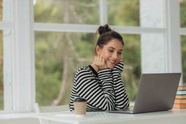 happy smiling girl doing work using laptop at home