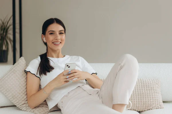 Image Smiling Woman Using Mobile Phone While Sitting Sofa — Stockfoto