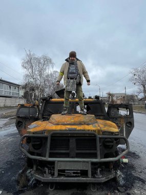 3 Mart 2022: Mahvolmuş askeri aracın üzerinde duran adam. Kharkiv, Ukrayna.
