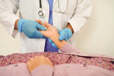 Doktor el ele tutuşuyor Asyalı yaşlı kadın hasta, hastanede yardım ve bakım.      