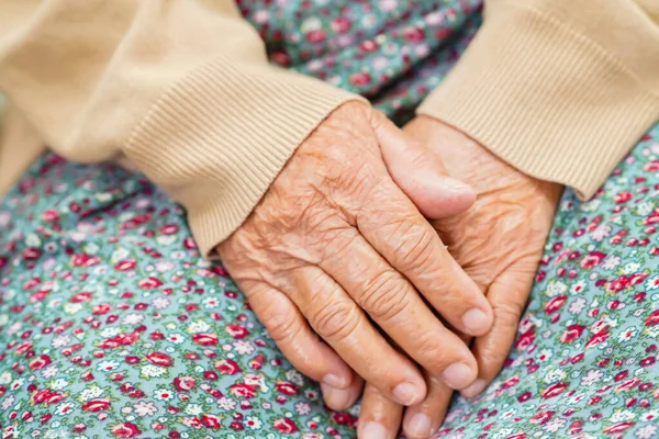 亚洲老年老年妇女病人坐在医院的床上 与她的手保持着密切的关系 — 图库照片