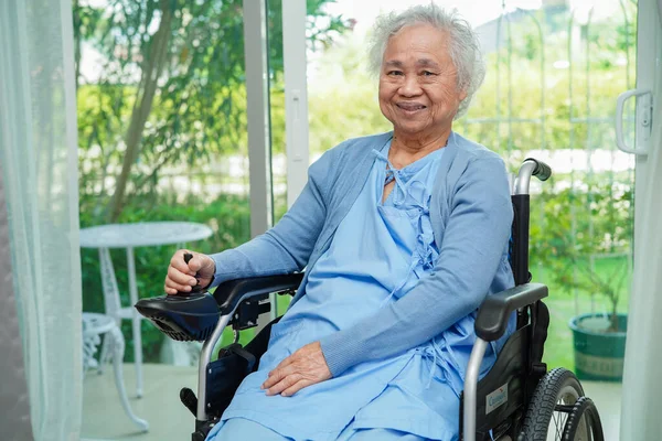 亚洲老年残疾妇女病人坐在公园的电动轮椅上 医学概念 — 图库照片