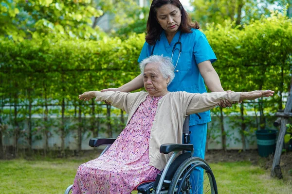 Doctor help Asian elderly woman disability patient in nursing hospital, medical concept.