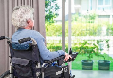 Parkta elektrikli sandalyede oturan Asyalı yaşlı kadın engelli hasta, tıbbi konsept..
