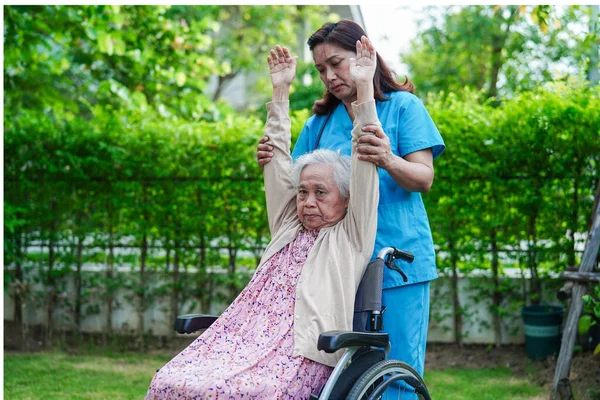 亚洲老年残疾妇女坐轮椅与医生在公园锻炼 医学概念 — 图库照片