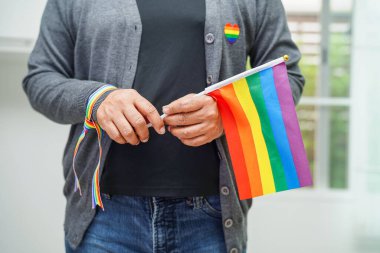 Asian woman with rainbow flag, LGBT symbol rights and gender equality, LGBT Pride Month in June.